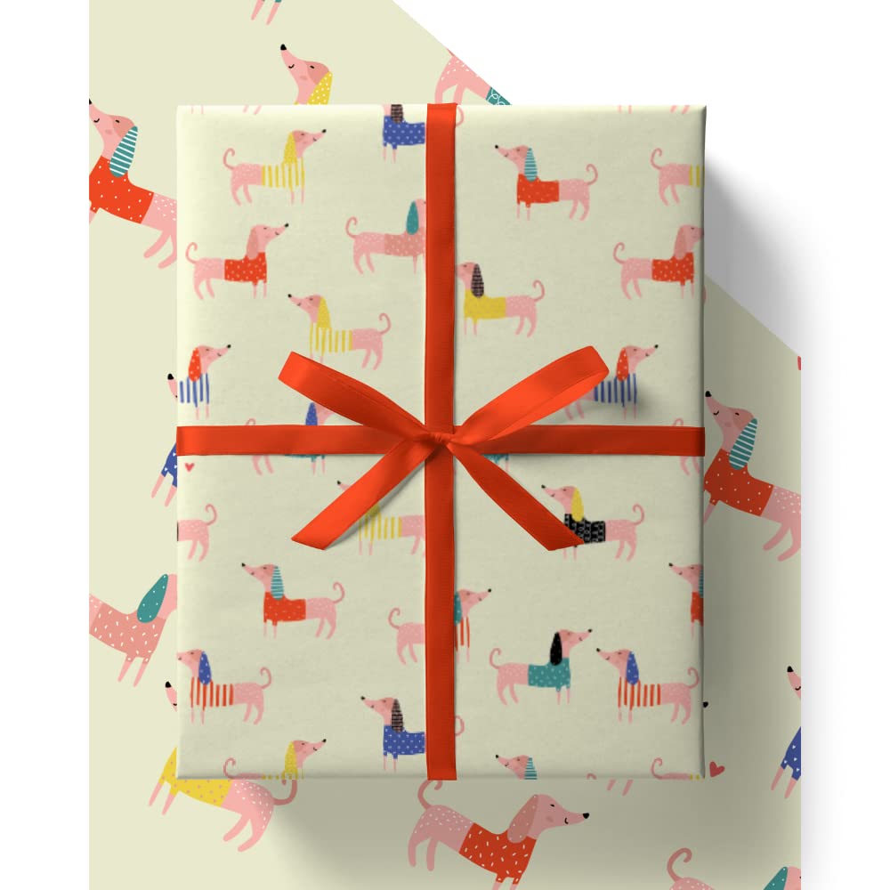 Gift box with colorful dachshund pattern and red ribbon on a white background