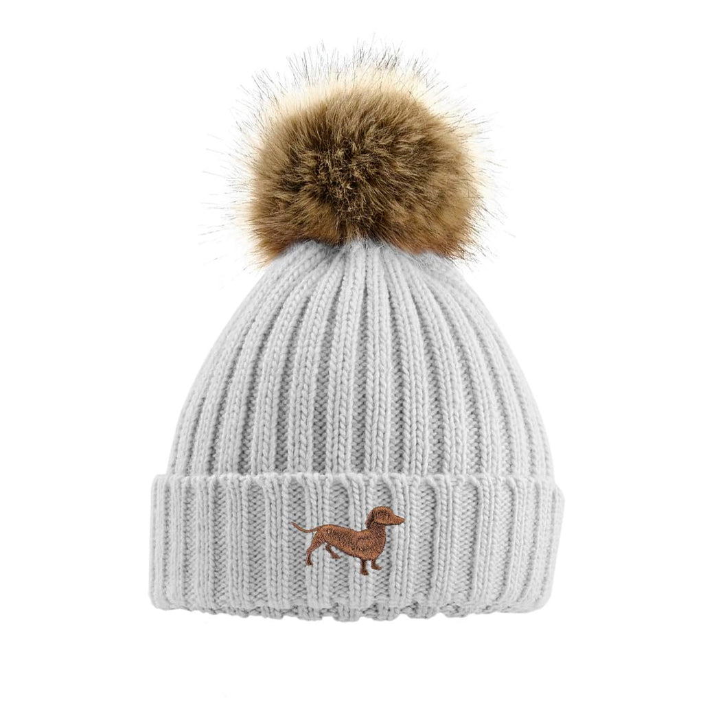 Gray knit beanie with a brown fur pom-pom and dachshund logo on a white background