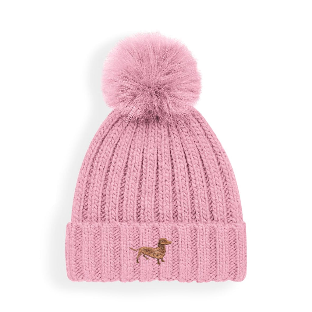 Pink knitted beanie with a pom-pom and dachsund logo on a white background